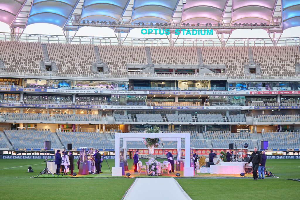 Full view of Optus Stadium during the VIP corporate dinner, with tables and lighting on the pitch.